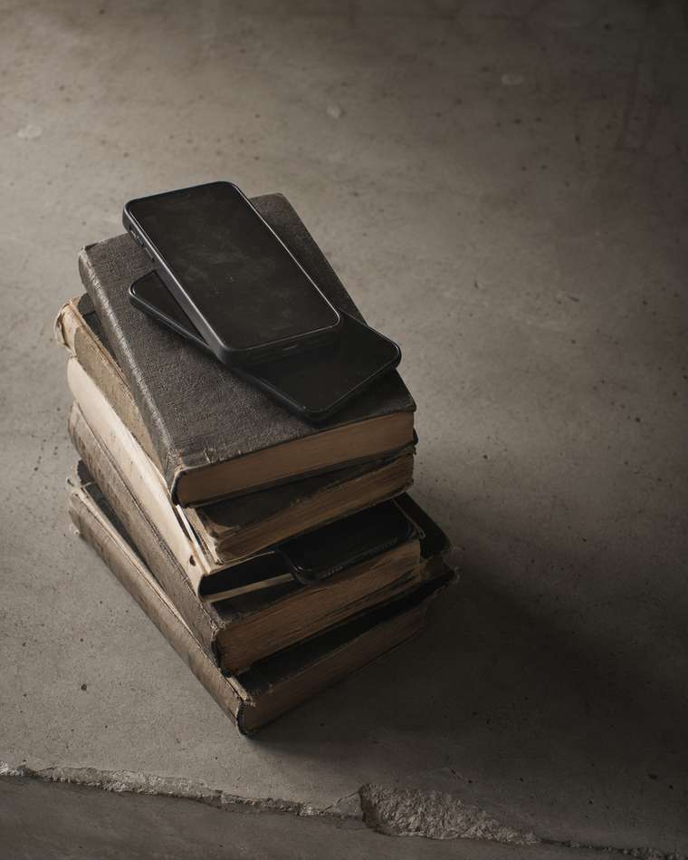 Pilha de livros com celulares empilhados em cima